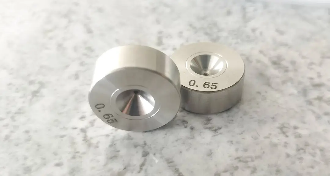 Ảnh chụp cận cảnh lỗ khuôn kéo dây với dung sai độ chính xác cao, cho thấy bề mặt bên trong nhẵn mịn phục vụ việc kéo dây mảnh.